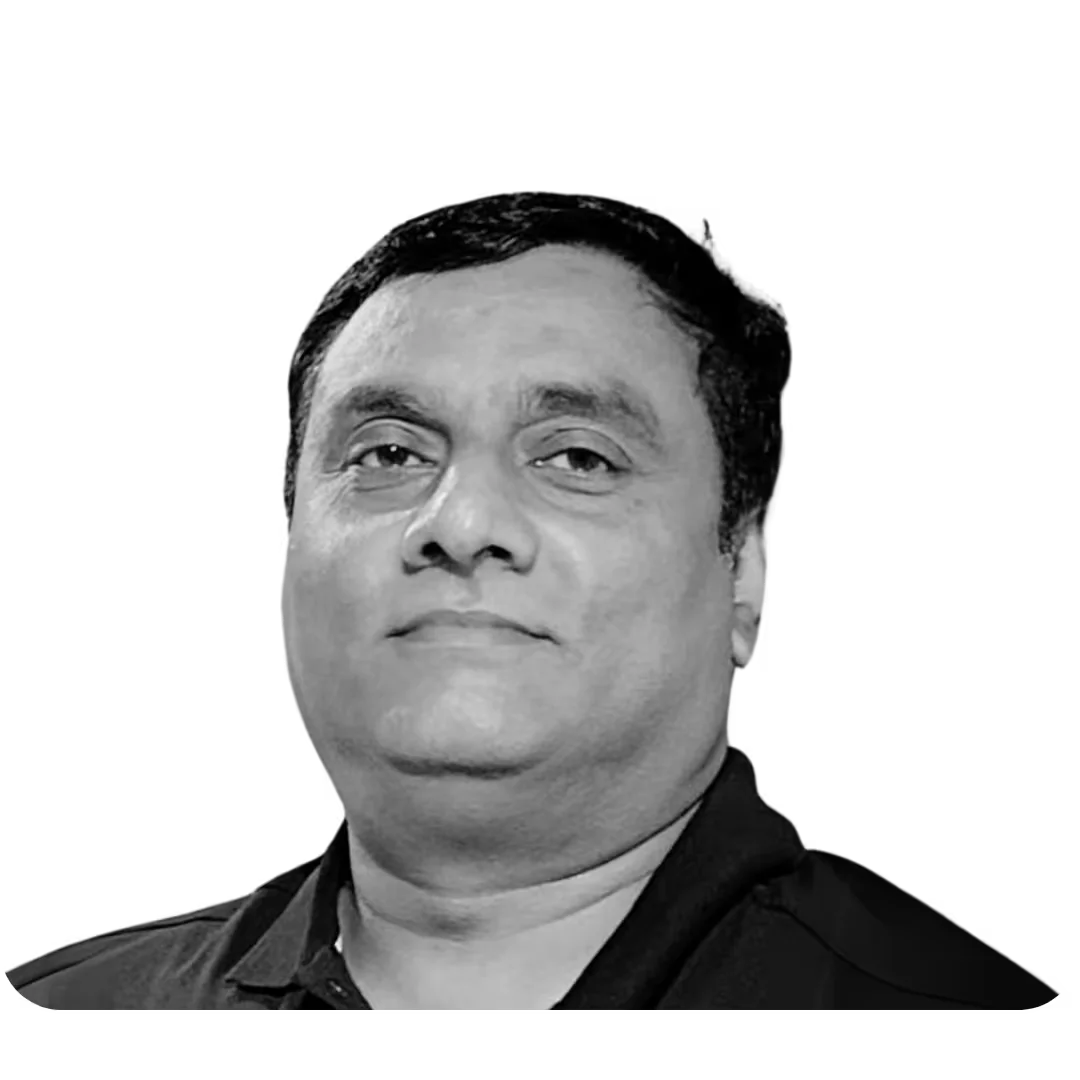 A grayscale portrait of a person with short, dark hair wearing a dark collared shirt, set against a solid black background.