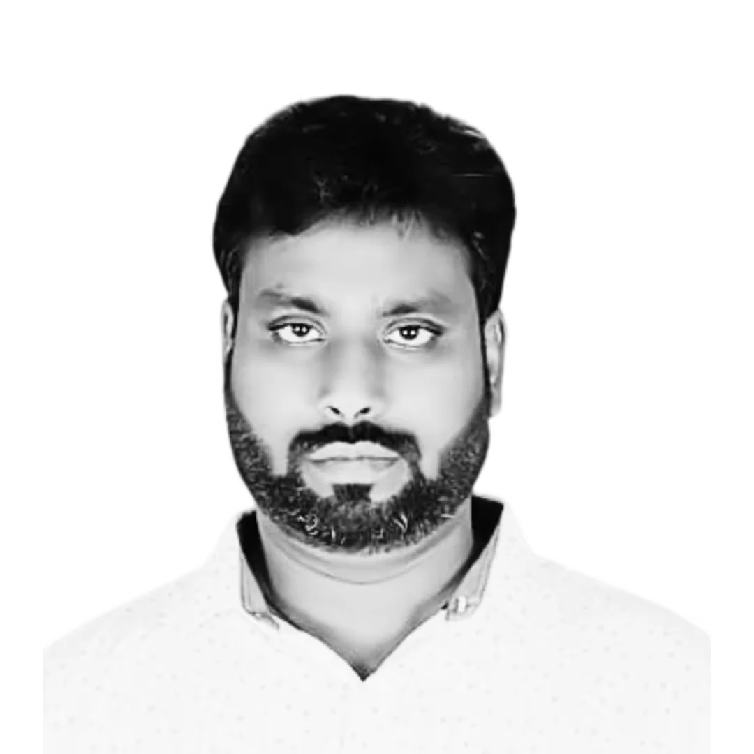 A man with a beard and a neutral expression is wearing a collared shirt. The background is plain black and white.